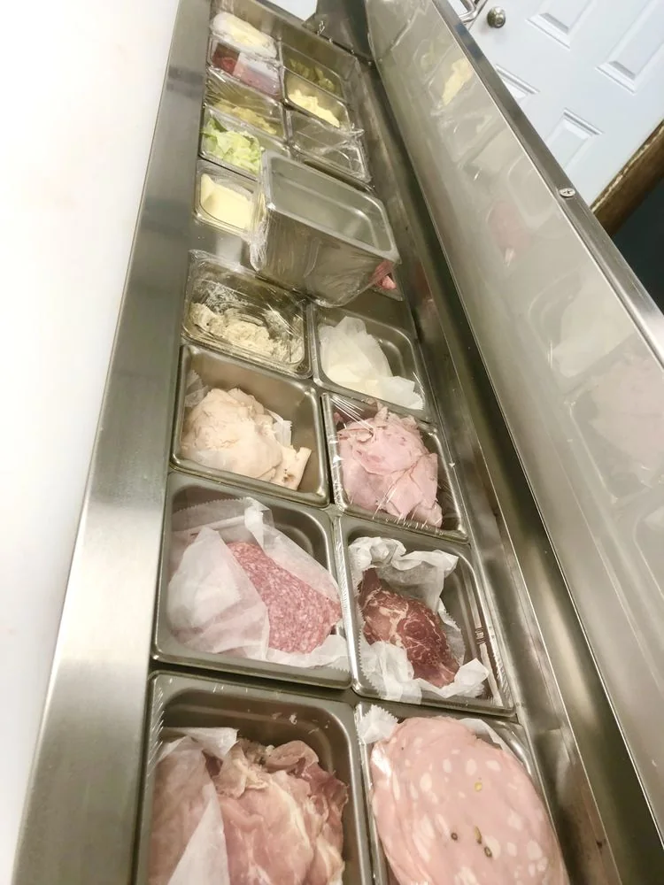 Trays of sliced deli meats in the case